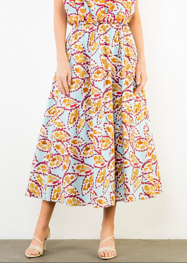 Midi skirt with multicolored leaf print in yellow, pink, and purple on light blue background, featuring an elastic waistband.
