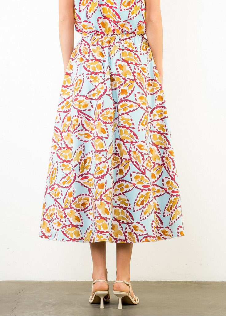 Flowy midi skirt with yellow, pink, and red leaf pattern on light blue background.