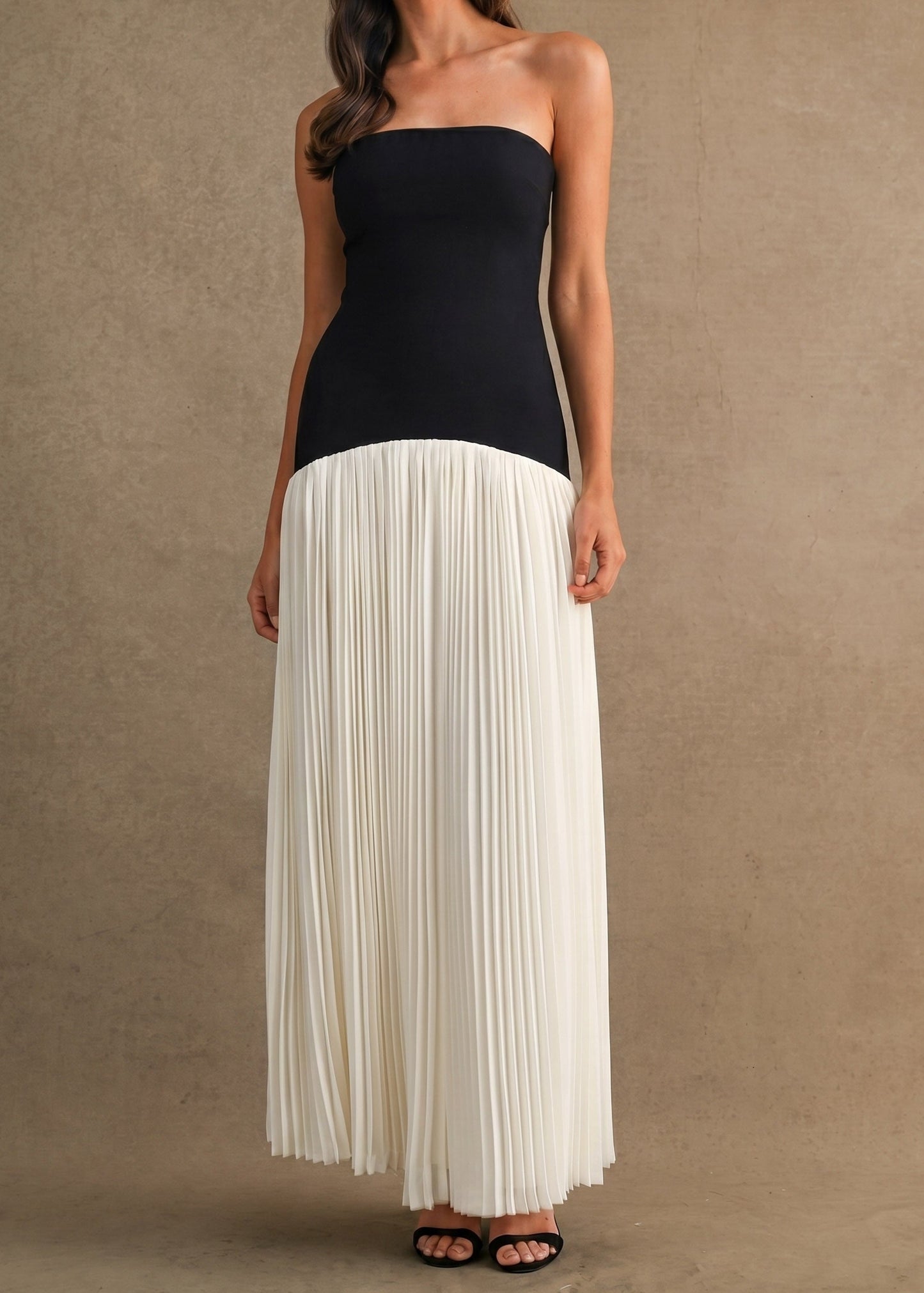 Black strapless maxi dress with white pleated skirt section.